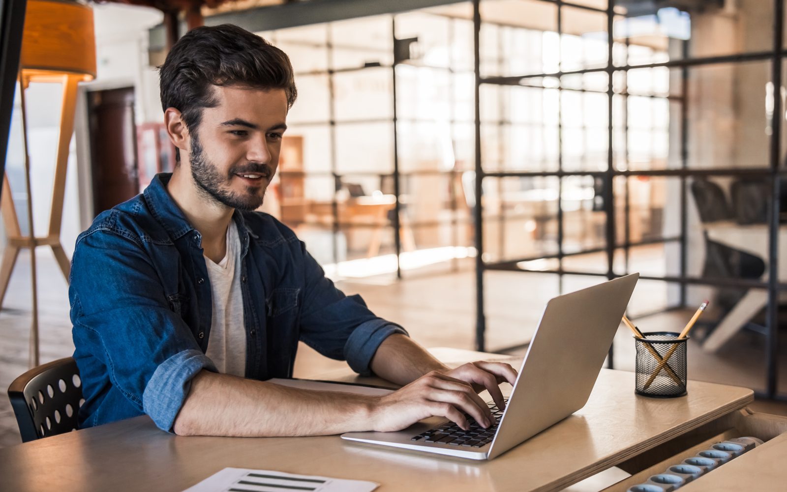 Marketer drafting a Google Business Profile offer post on a laptop at a shared workspace desk