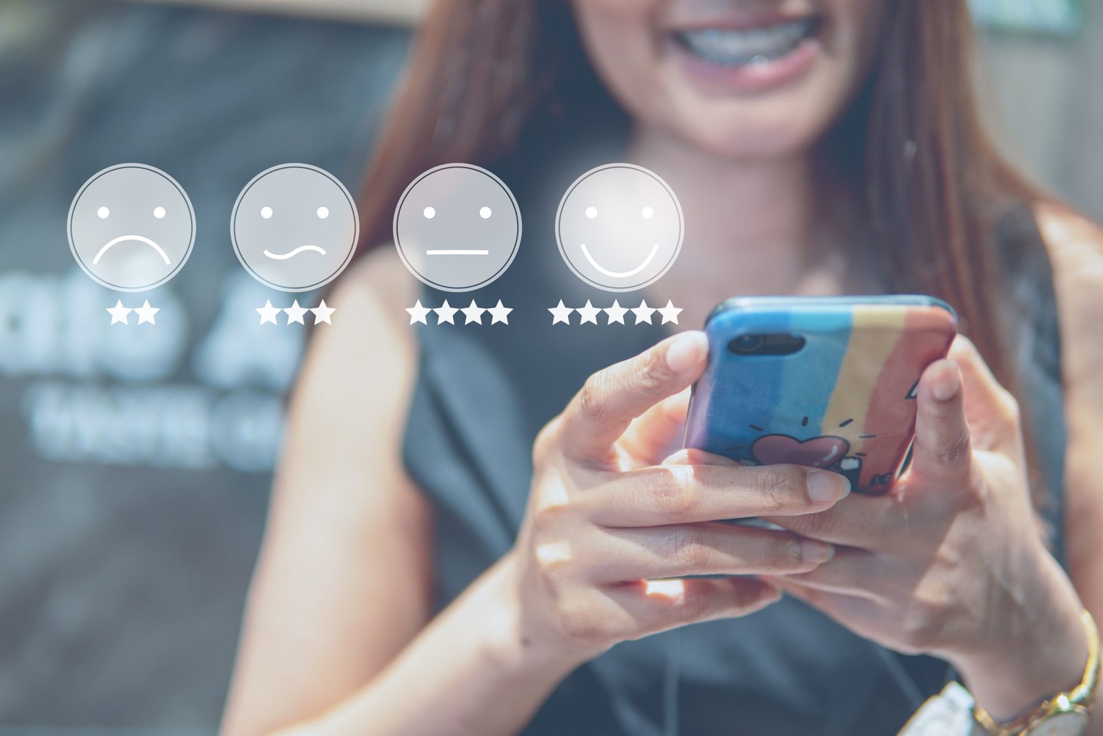 Customer selecting a rating on her phone with one to five star options and matching face icons displayed